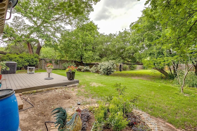 view of yard featuring a fenced backyard, central AC, and a deck