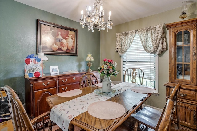 dining area with a textured wall and a chandelier