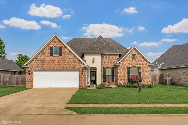 traditional home with fence, driveway, a front lawn, and a garage