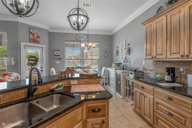 kitchen with visible vents, a sink, dark stone countertops, an inviting chandelier, and light tile patterned flooring