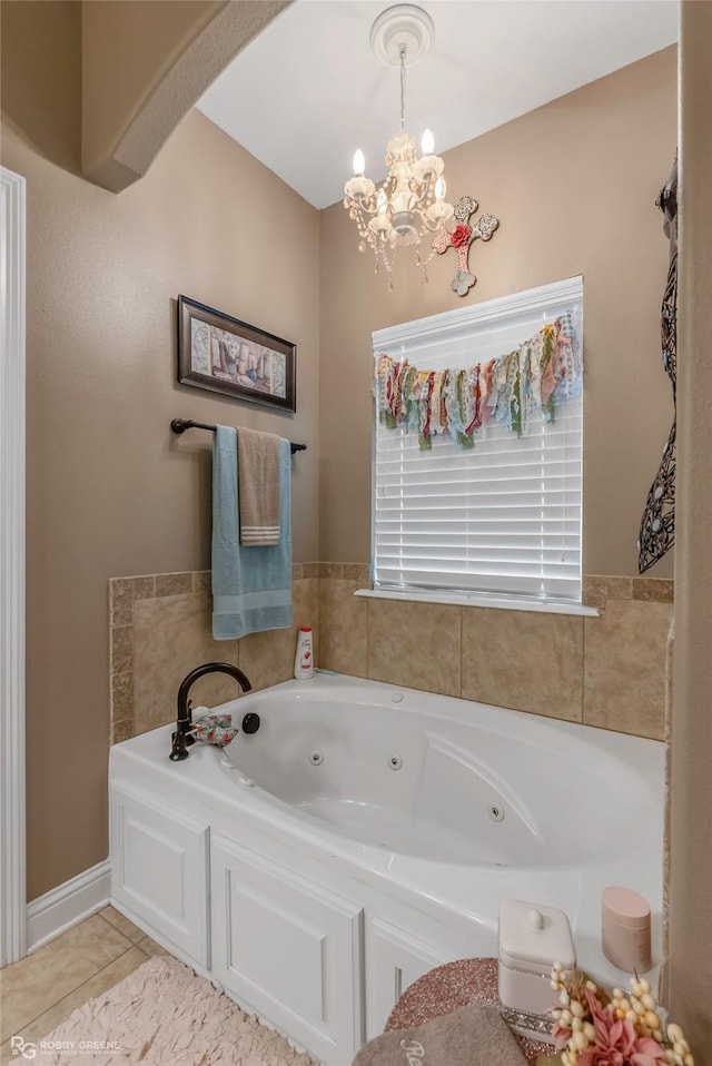full bathroom with a jetted tub, tile patterned flooring, and a notable chandelier