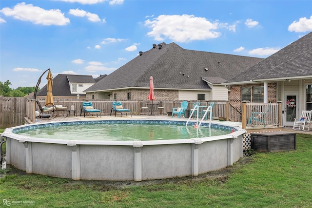 view of pool featuring a yard, a deck, a fenced in pool, and fence