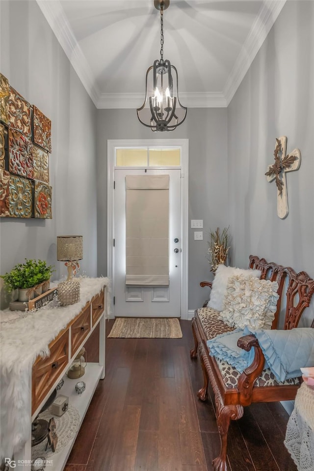 foyer with crown molding, an inviting chandelier, and dark wood-type flooring
