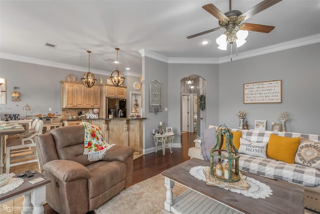 living room featuring arched walkways, wood finished floors, ceiling fan with notable chandelier, ornamental molding, and recessed lighting