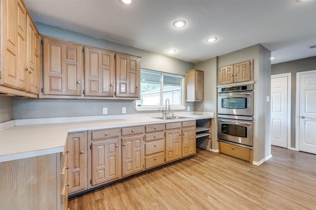 2400 N Shore Dr, Bonham, TX 75418 - kitchen with stainless steel double oven, a sink, light wood finished floors, and light countertops