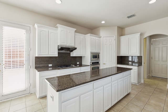 kitchen with visible vents, stainless steel appliances, tasteful backsplash, light tile patterned floors, and under cabinet range hood