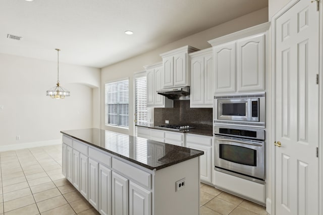 kitchen with stainless steel appliances, white cabinetry, light tile patterned floors, under cabinet range hood, and visible vents