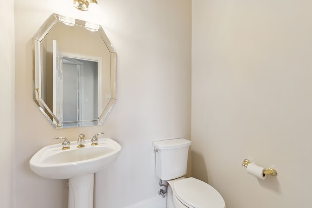 bathroom with toilet and baseboards