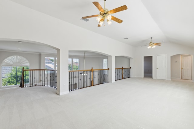 carpeted empty room with baseboards, ceiling fan, vaulted ceiling, and visible vents