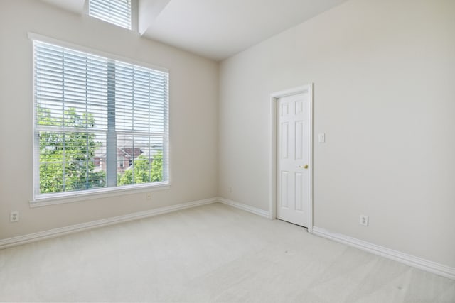 carpeted empty room featuring baseboards