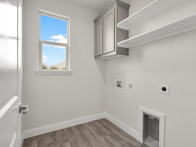 laundry area with wood finished floors, baseboards, hookup for a washing machine, electric dryer hookup, and cabinet space