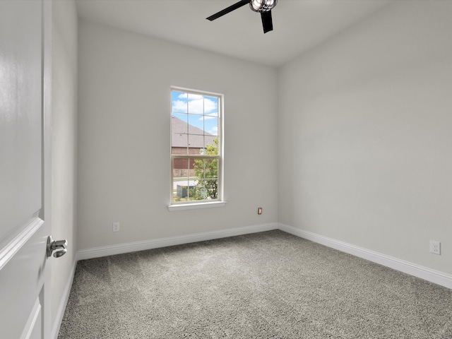 carpeted spare room with a ceiling fan and baseboards
