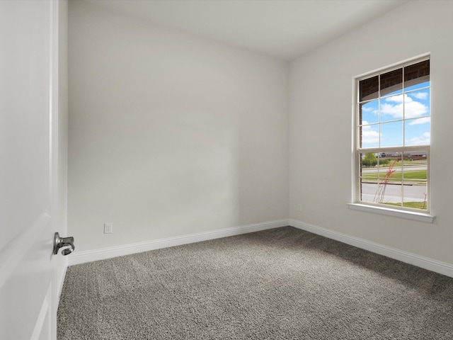 empty room featuring baseboards and carpet