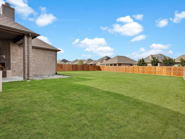view of yard featuring a fenced backyard and a residential view