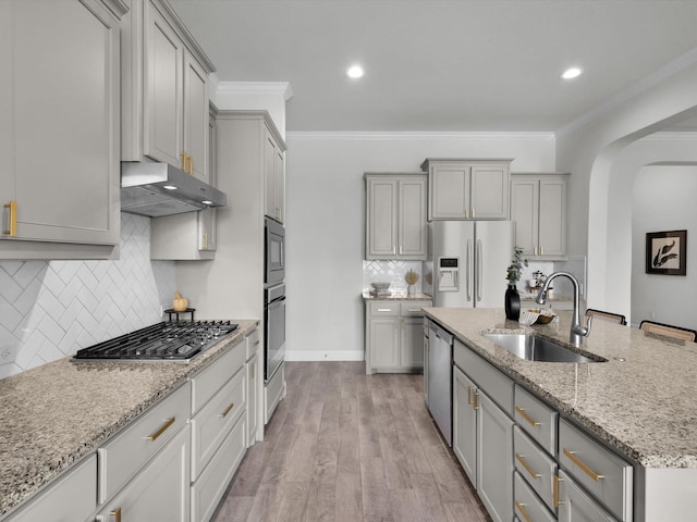 kitchen with a sink, gray cabinets, stainless steel appliances, and under cabinet range hood
