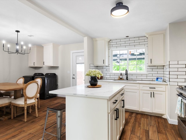 1821 Melissa St, Arlington, TX 76010 - kitchen featuring an inviting chandelier, decorative backsplash, washer and clothes dryer, a sink, and stainless steel electric range oven