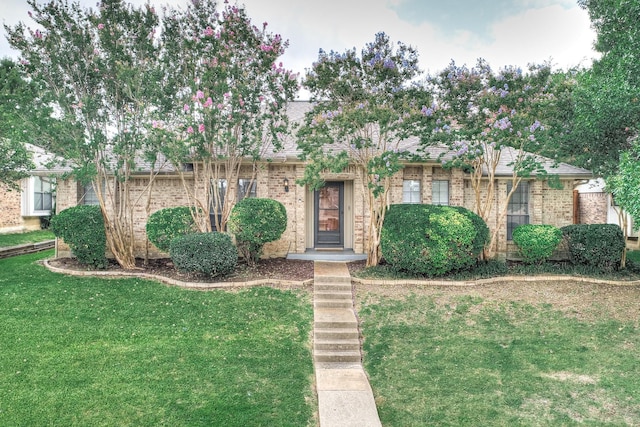 ranch-style home with brick siding and a front yard