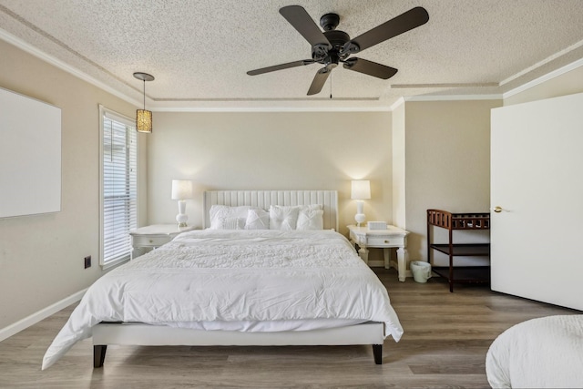 bedroom featuring crown molding, a textured ceiling, ceiling fan, and wood finished floors