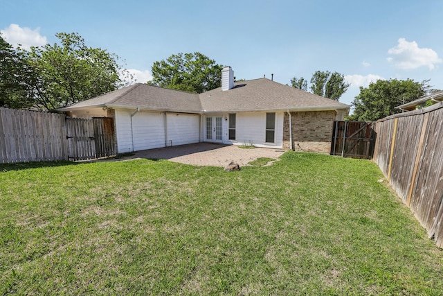 back of house with an attached garage, french doors, a gate, and a fenced backyard