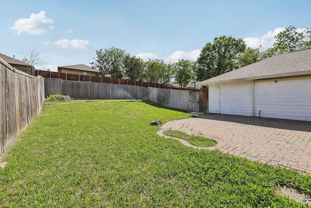 view of yard featuring a fenced backyard, a patio area, and a garage