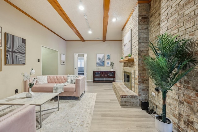 living room featuring crown molding, a fireplace, light wood-type flooring, and brick wall