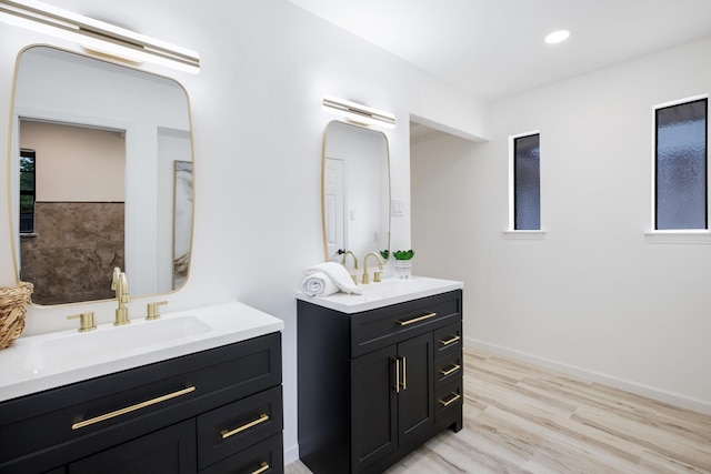 full bath with wood finished floors, a sink, two vanities, and recessed lighting