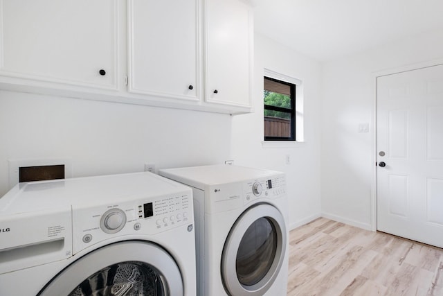 clothes washing area featuring light wood-style floors, cabinet space, independent washer and dryer, and baseboards