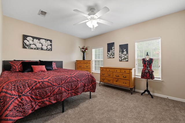 bedroom with carpet flooring, baseboards, visible vents, and multiple windows