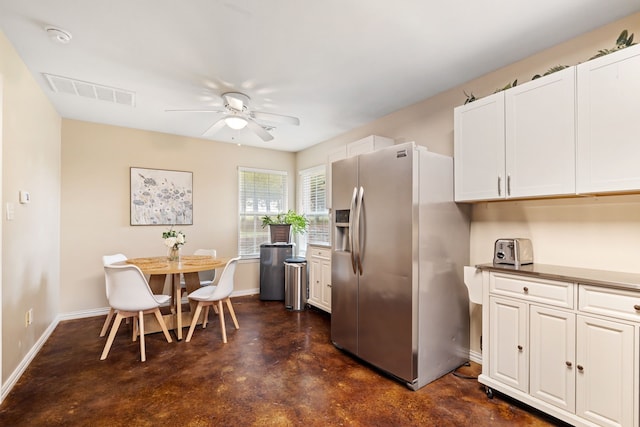 kitchen with visible vents, finished concrete flooring, baseboards, ceiling fan, and stainless steel fridge