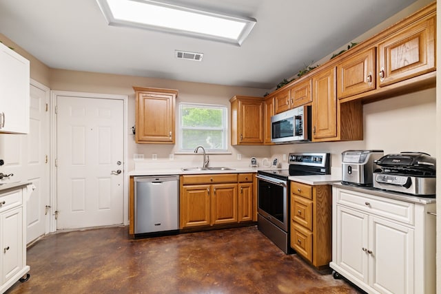 kitchen with visible vents, a sink, light countertops, concrete floors, and stainless steel appliances