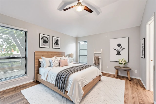 bedroom featuring light wood-style floors, baseboards, and ceiling fan