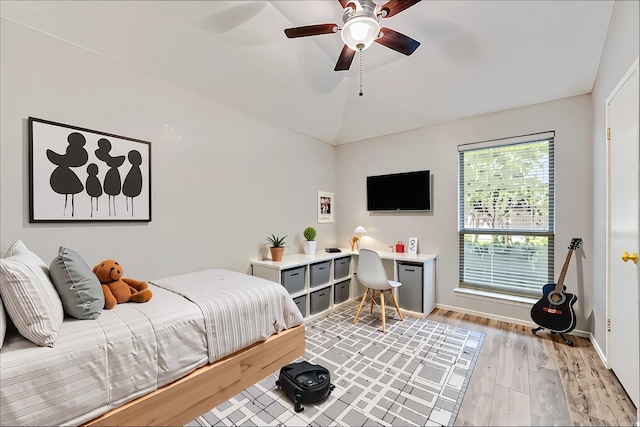 bedroom featuring light wood-style floors, a ceiling fan, baseboards, and lofted ceiling