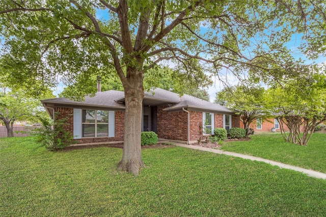 single story home featuring brick siding, roof with shingles, and a front lawn