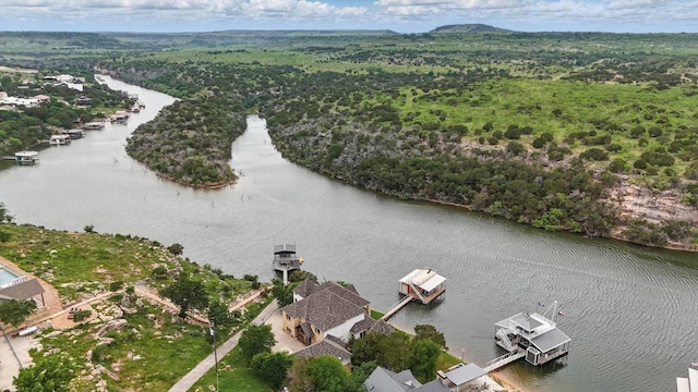 drone / aerial view with a water view and a forest view