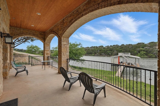 view of patio featuring a water view and a balcony
