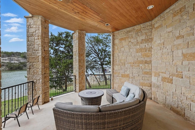 view of patio featuring a water view and a balcony