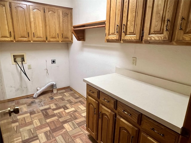 washroom with gas dryer hookup, washer hookup, electric dryer hookup, cabinet space, and baseboards