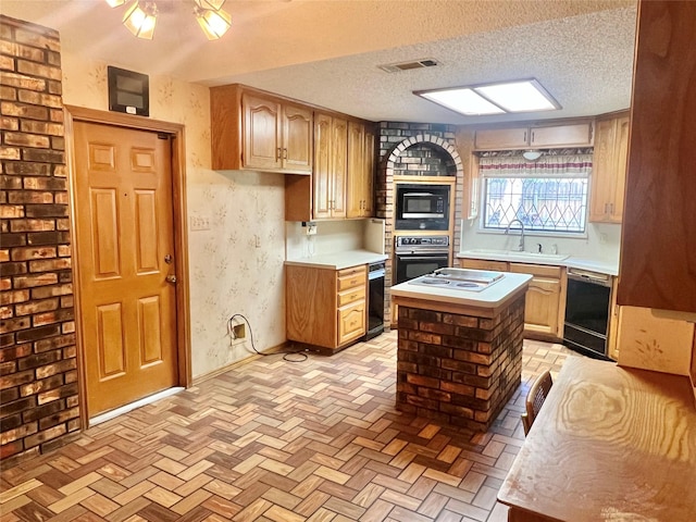 kitchen with light countertops, visible vents, a sink, and black appliances