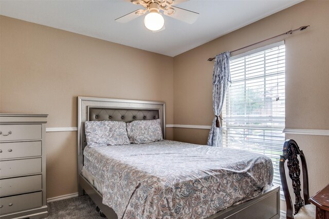 bedroom with a ceiling fan, baseboards, multiple windows, and carpet