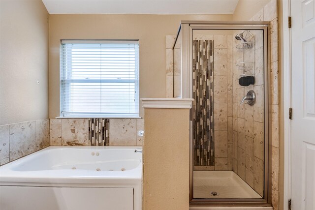 full bathroom with a whirlpool tub and a shower stall
