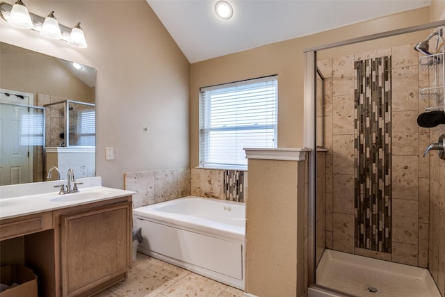 bathroom with lofted ceiling, a shower stall, a garden tub, and vanity