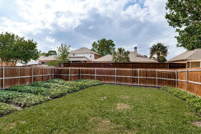 rear view of property with brick siding, a fenced backyard, a chimney, a lawn, and a patio