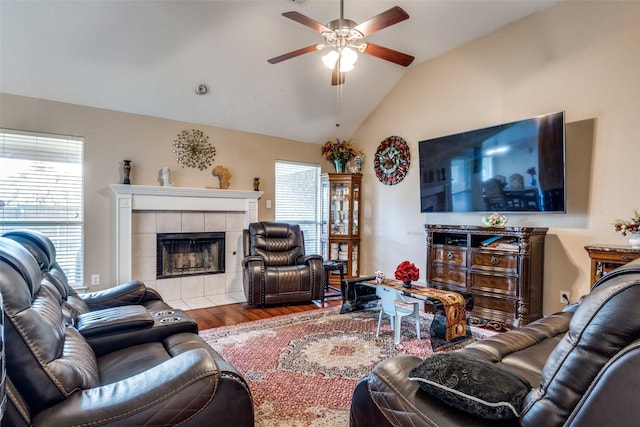 living room with a fireplace, plenty of natural light, a ceiling fan, wood finished floors, and lofted ceiling