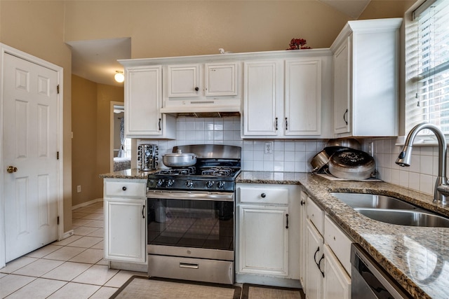 kitchen featuring under cabinet range hood, white cabinets, tasteful backsplash, a sink, and stainless steel appliances