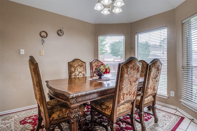 dining space with an inviting chandelier, baseboards, and light tile patterned floors