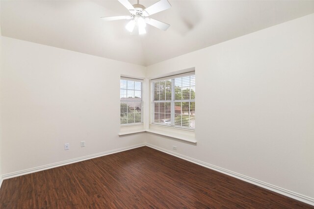 spare room featuring dark wood-style flooring, baseboards, a ceiling fan, and lofted ceiling