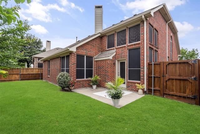 back of house with brick siding, a fenced backyard, a gate, a chimney, and a patio