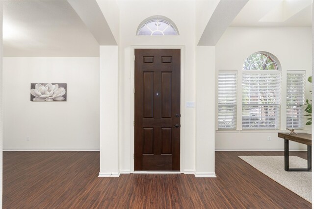 foyer entrance with dark wood-type flooring and baseboards