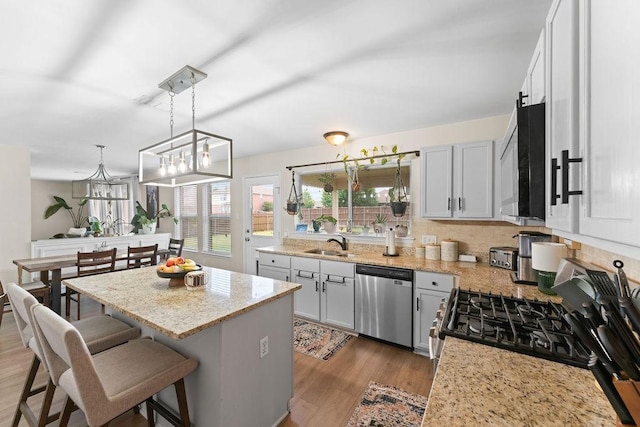 300 Aspenwood Trl, Forney, TX 75126 - kitchen featuring a kitchen breakfast bar, a center island, wood finished floors, a sink, and stainless steel appliances