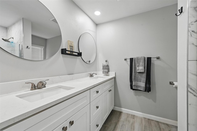 2108 Stonegate Dr N, Bedford, TX 76021 - bathroom featuring double vanity, a sink, baseboards, and wood finished floors